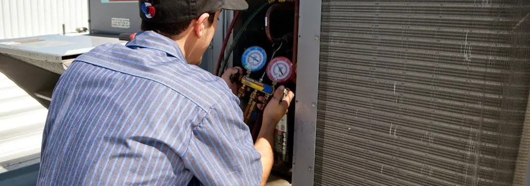 HVAC technician servicing a condenser unit in Waldorf
